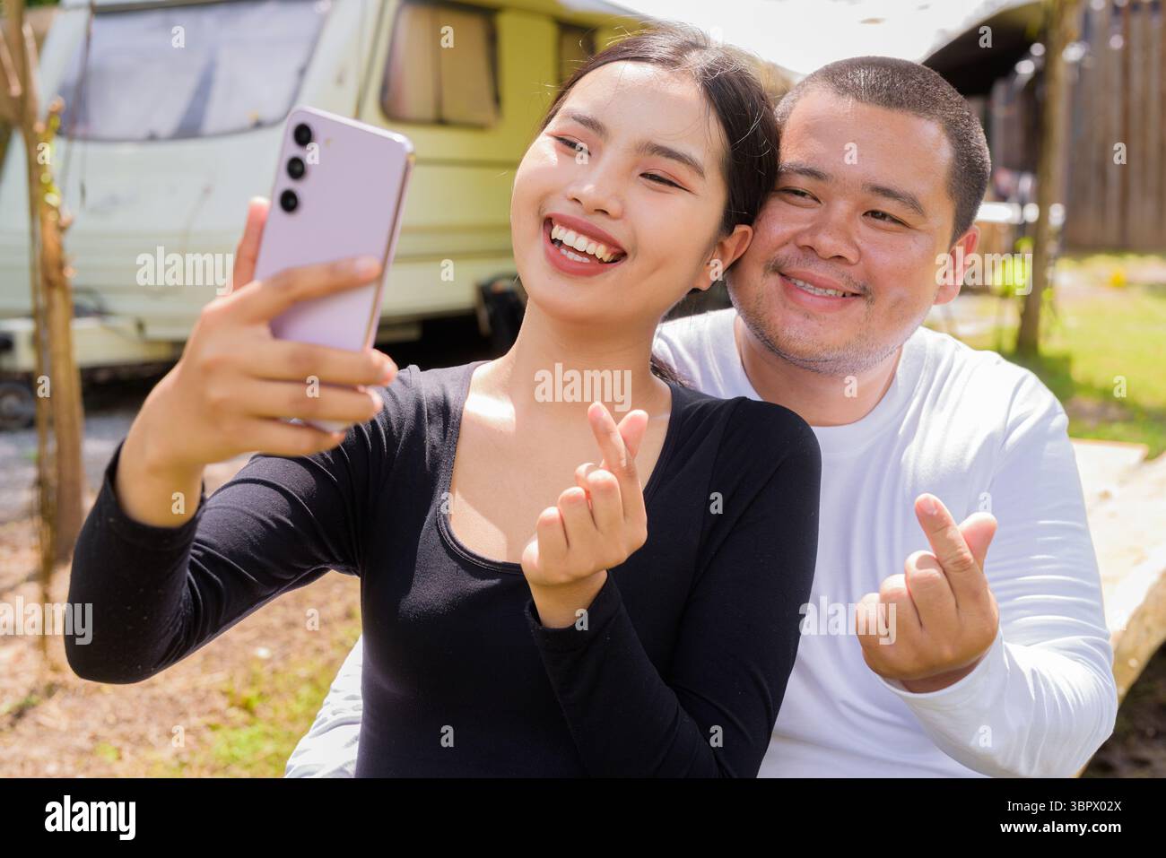 Coppie asiatiche in campeggio con il loro camper Foto Stock