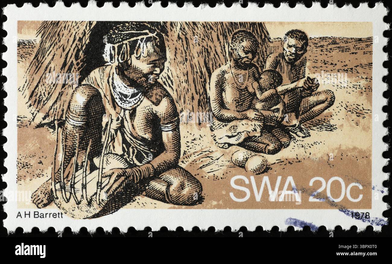 Bushman di fronte a una capanna sul francobollo sudafricano Foto Stock