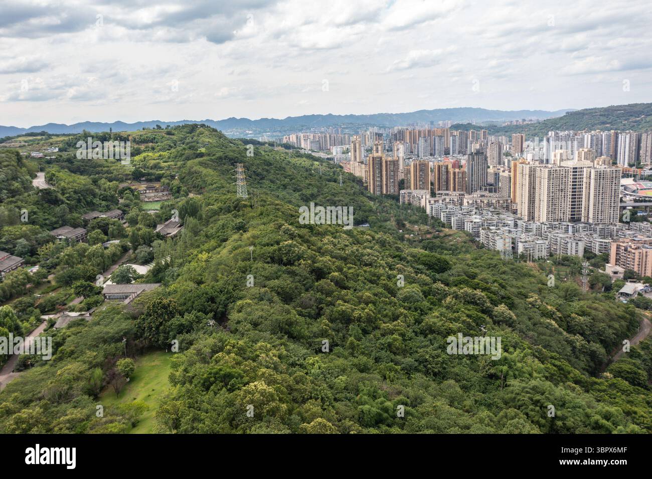 (250710) -- CHONGQING, 10 luglio 2025 (Xinhua) -- questa foto aerea del drone scattata il 3 luglio 2025 mostra la vista di un parco nel distretto di Jiangjin, nel comune di Chongqing della Cina sud-occidentale. Jiangjin si trova in un punto strategico lungo il fiume Yangtze. Gli edifici cittadini sono stati costruiti lungo le pendici sulle rive del fiume. Da lontano, sembrano una foresta che cresce dalle scogliere. Negli ultimi anni, Jiangjin ha promosso la gestione ecologica del fiume Yangtze. Il miglioramento della qualità dell'acqua ha attratto le specie ittiche rare a ritornare. (Xinhua/Huang Wei) Foto Stock