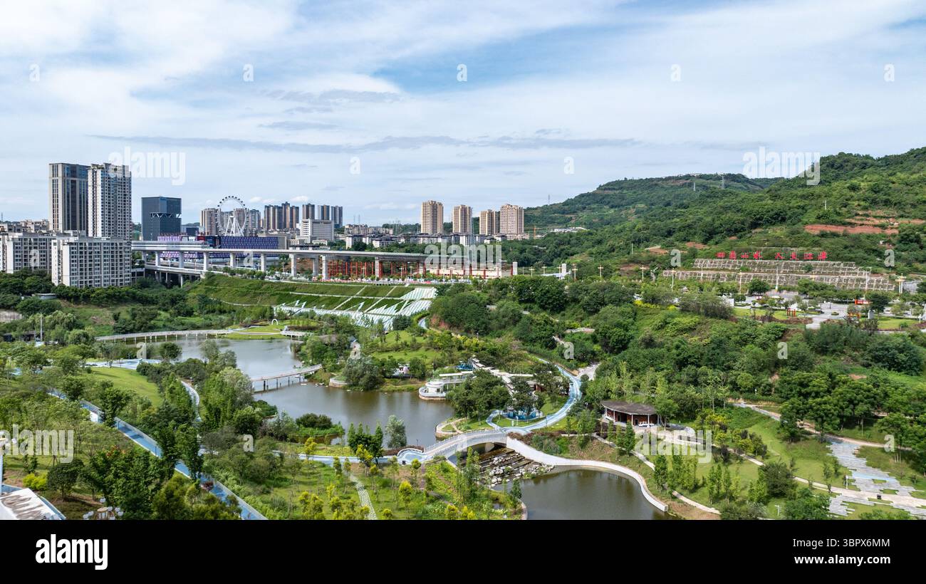 (250710) -- CHONGQING, 10 luglio 2025 (Xinhua) -- questa foto aerea del drone scattata il 3 luglio 2025 mostra la vista di un parco nel distretto di Jiangjin, nel comune di Chongqing della Cina sud-occidentale. Jiangjin si trova in un punto strategico lungo il fiume Yangtze. Gli edifici cittadini sono stati costruiti lungo le pendici sulle rive del fiume. Da lontano, sembrano una foresta che cresce dalle scogliere. Negli ultimi anni, Jiangjin ha promosso la gestione ecologica del fiume Yangtze. Il miglioramento della qualità dell'acqua ha attratto le specie ittiche rare a ritornare. (Xinhua/Huang Wei) Foto Stock