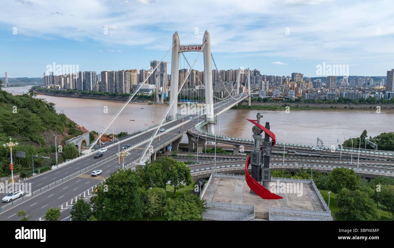 (250710) -- CHONGQING, 10 luglio 2025 (Xinhua) -- questa foto aerea con drone scattata il 3 luglio 2025 mostra la vista del ponte sul fiume Yangtze di Jijiang nel distretto di Jiangjin, nel comune di Chongqing della Cina sud-occidentale. Jiangjin si trova in un punto strategico lungo il fiume Yangtze. Gli edifici cittadini sono stati costruiti lungo le pendici sulle rive del fiume. Da lontano, sembrano una foresta che cresce dalle scogliere. Negli ultimi anni, Jiangjin ha promosso la gestione ecologica del fiume Yangtze. Il miglioramento della qualità dell'acqua ha attratto le specie ittiche rare a ritornare. (Xinhua/Huang Wei Foto Stock