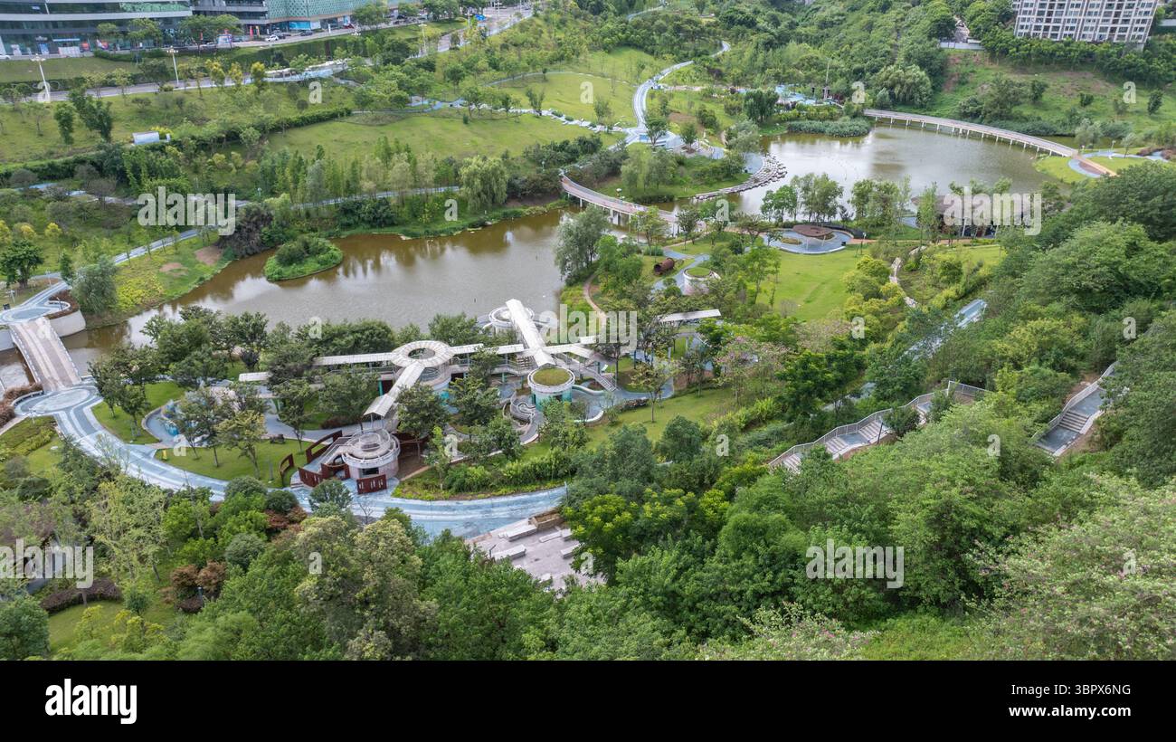(250710) -- CHONGQING, 10 luglio 2025 (Xinhua) -- questa foto aerea del drone scattata il 3 luglio 2025 mostra la vista di un parco nel distretto di Jiangjin, nel comune di Chongqing della Cina sud-occidentale. Jiangjin si trova in un punto strategico lungo il fiume Yangtze. Gli edifici cittadini sono stati costruiti lungo le pendici sulle rive del fiume. Da lontano, sembrano una foresta che cresce dalle scogliere. Negli ultimi anni, Jiangjin ha promosso la gestione ecologica del fiume Yangtze. Il miglioramento della qualità dell'acqua ha attratto le specie ittiche rare a ritornare. (Xinhua/Huang Wei) Foto Stock