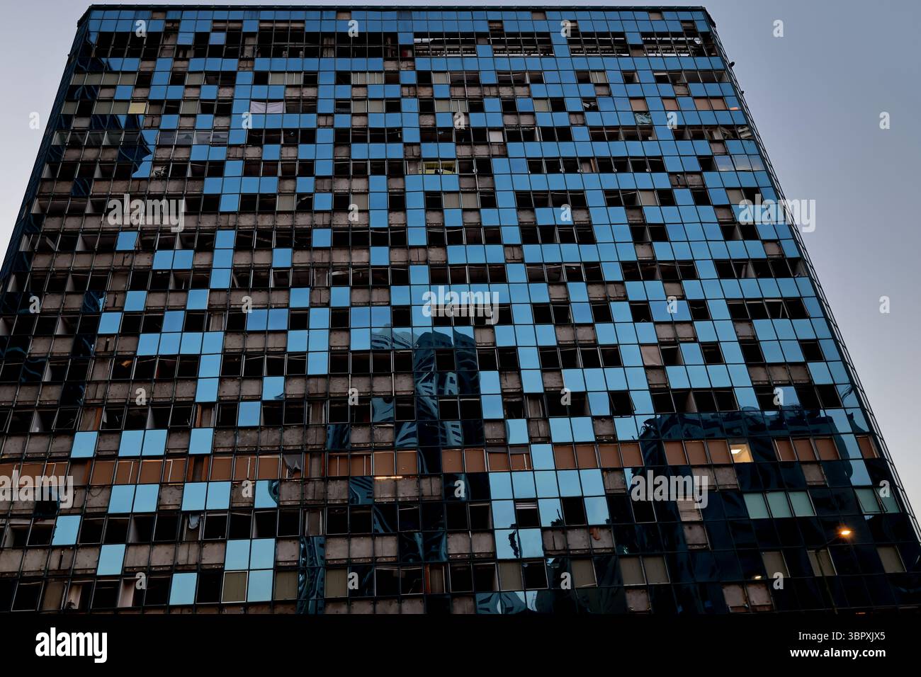 I pannelli di vetro fratturati formano un mosaico frastagliato su un grattacielo Ramat Gan, che testimonia silenziosamente gli attacchi missilistici e lo spirito civile risoluto e duraturo. Foto Stock