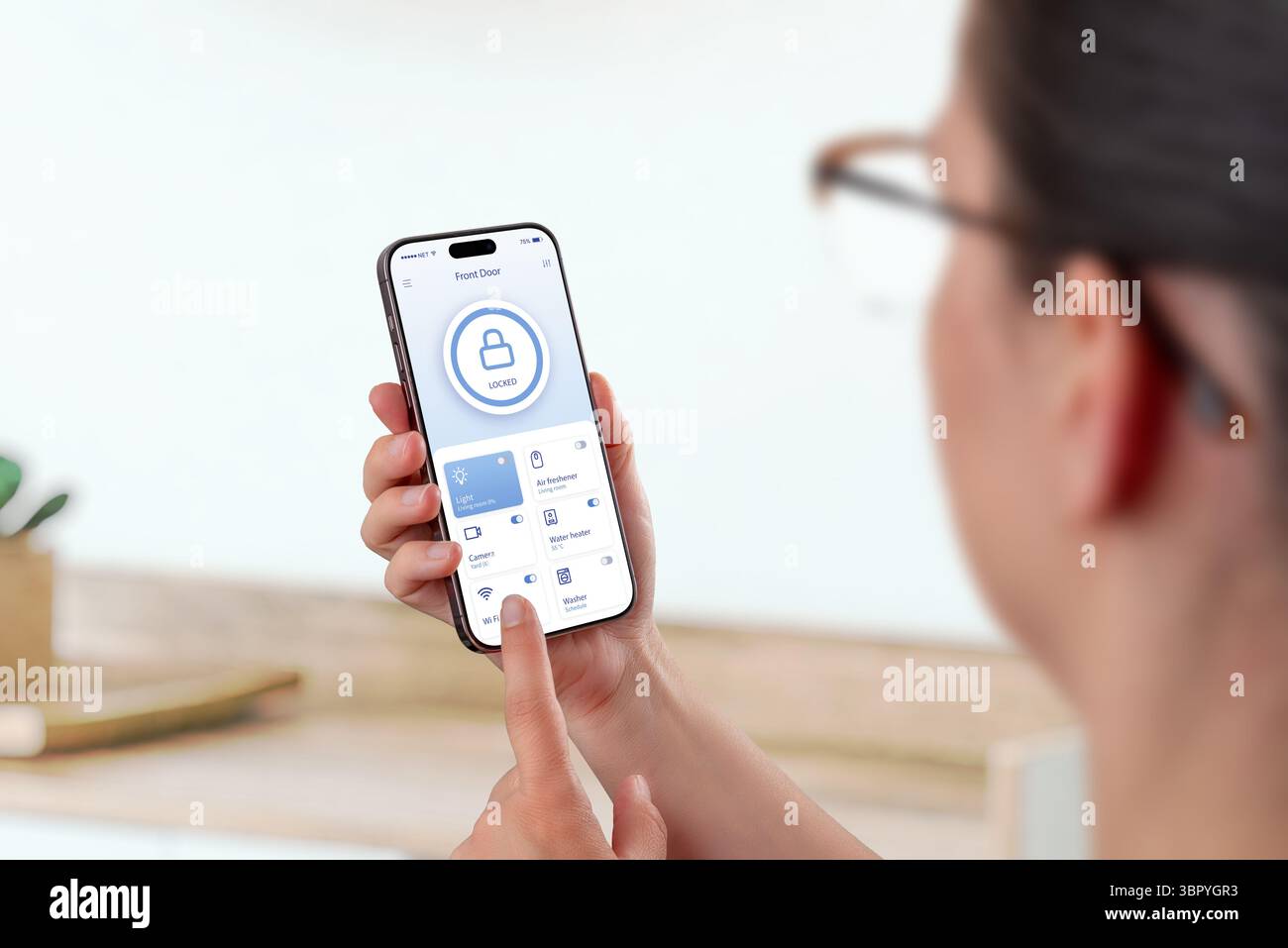 Donna che utilizza un'app per smartphone smart home con blocco porta e funzioni di gestione dei dispositivi Foto Stock