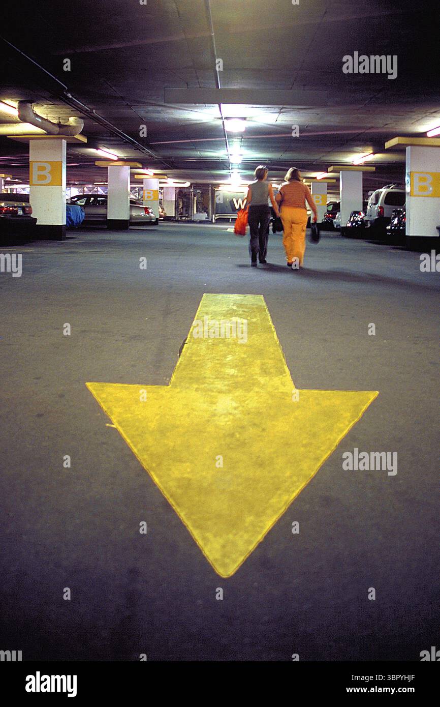 Freccia direzionale gialla in un alto parcheggio, New York City, USA Foto Stock
