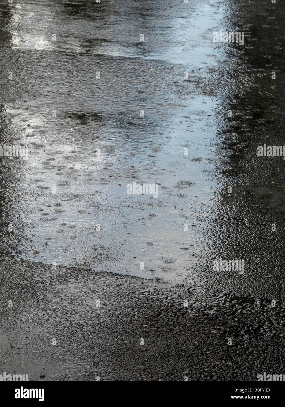 Pioggia intensa sulla strada a, immagine ravvicinata. con le pozzanghere. Foto Stock