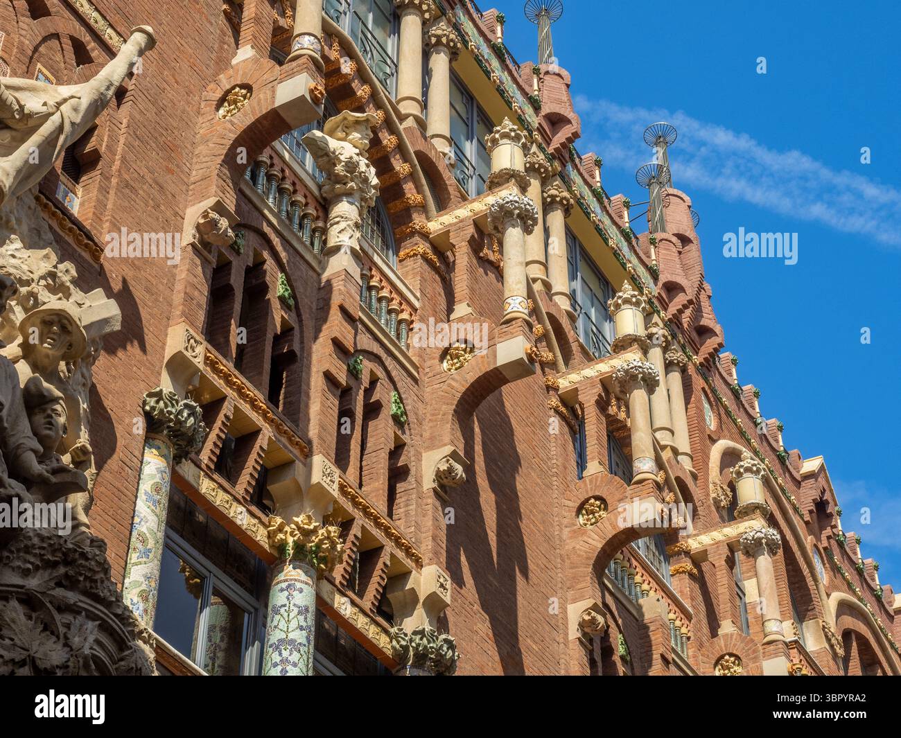 Dettaglio delle decorazioni in mattoni, colonne scultoree e mosaici sulla facciata modernista del Palau de la Música Catalana, Barcellona, Spagna. Foto Stock