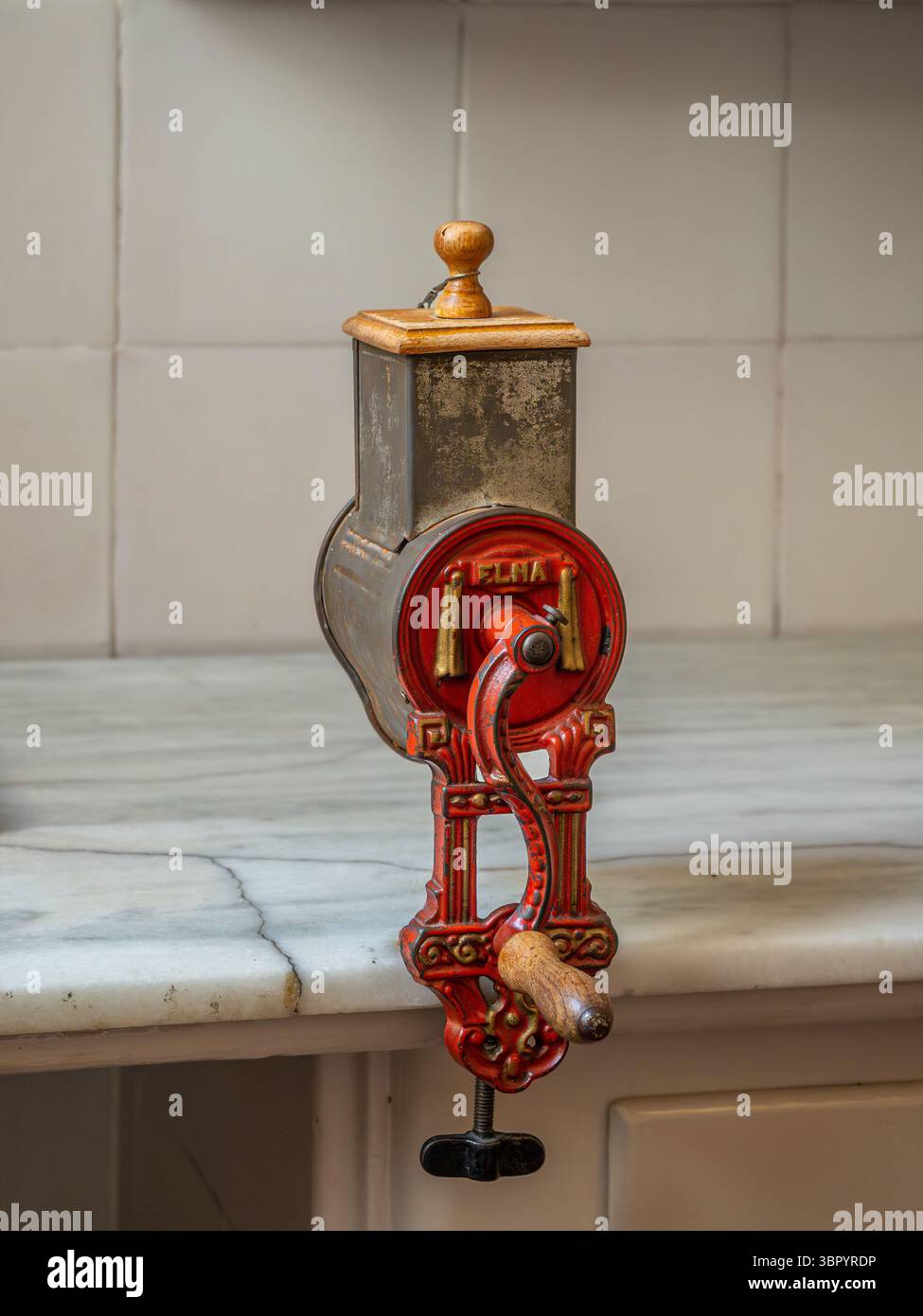 Un'antica smerigliatrice a manovella fissata a un ripiano in marmo nella cucina restaurata dell'appartamento Casa Milà di Barcellona, Spagna. Foto Stock