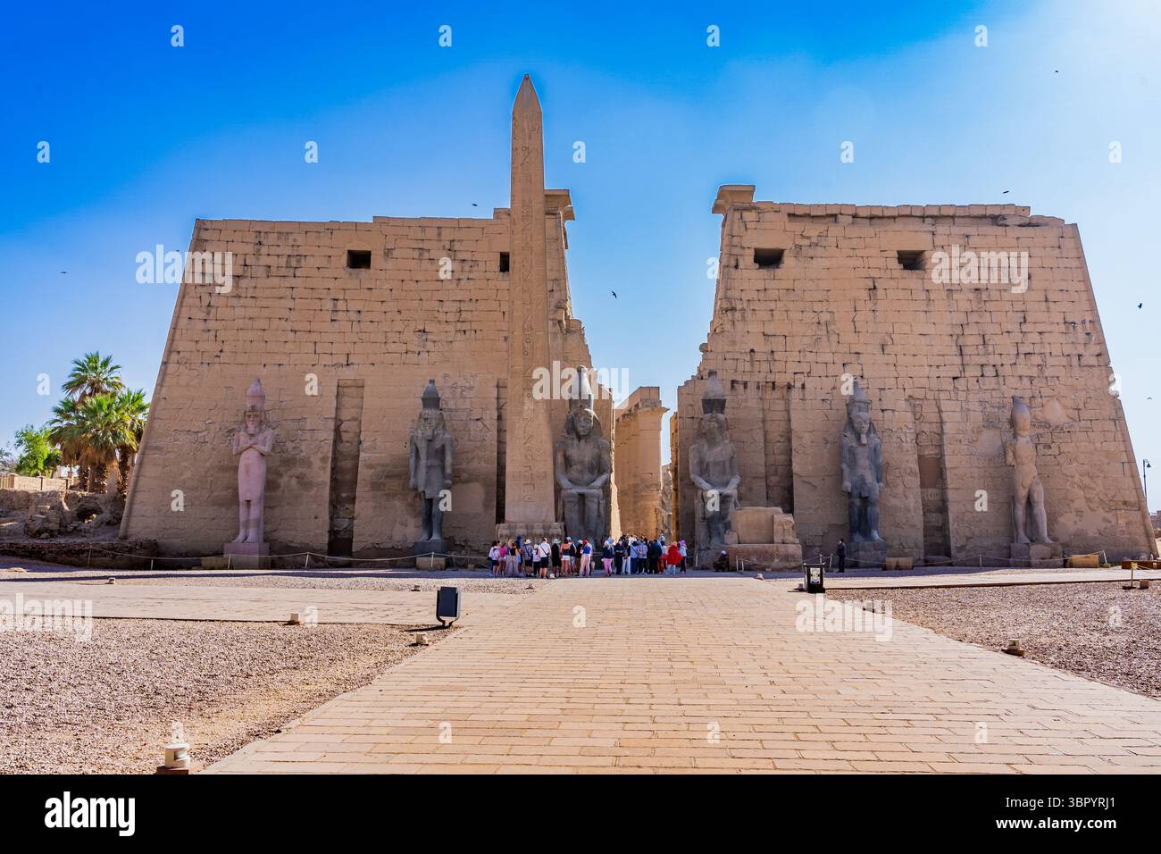 Vista del primo pilone del tempio di Luxor con l'imponente statua di Ramses II, Egitto Foto Stock