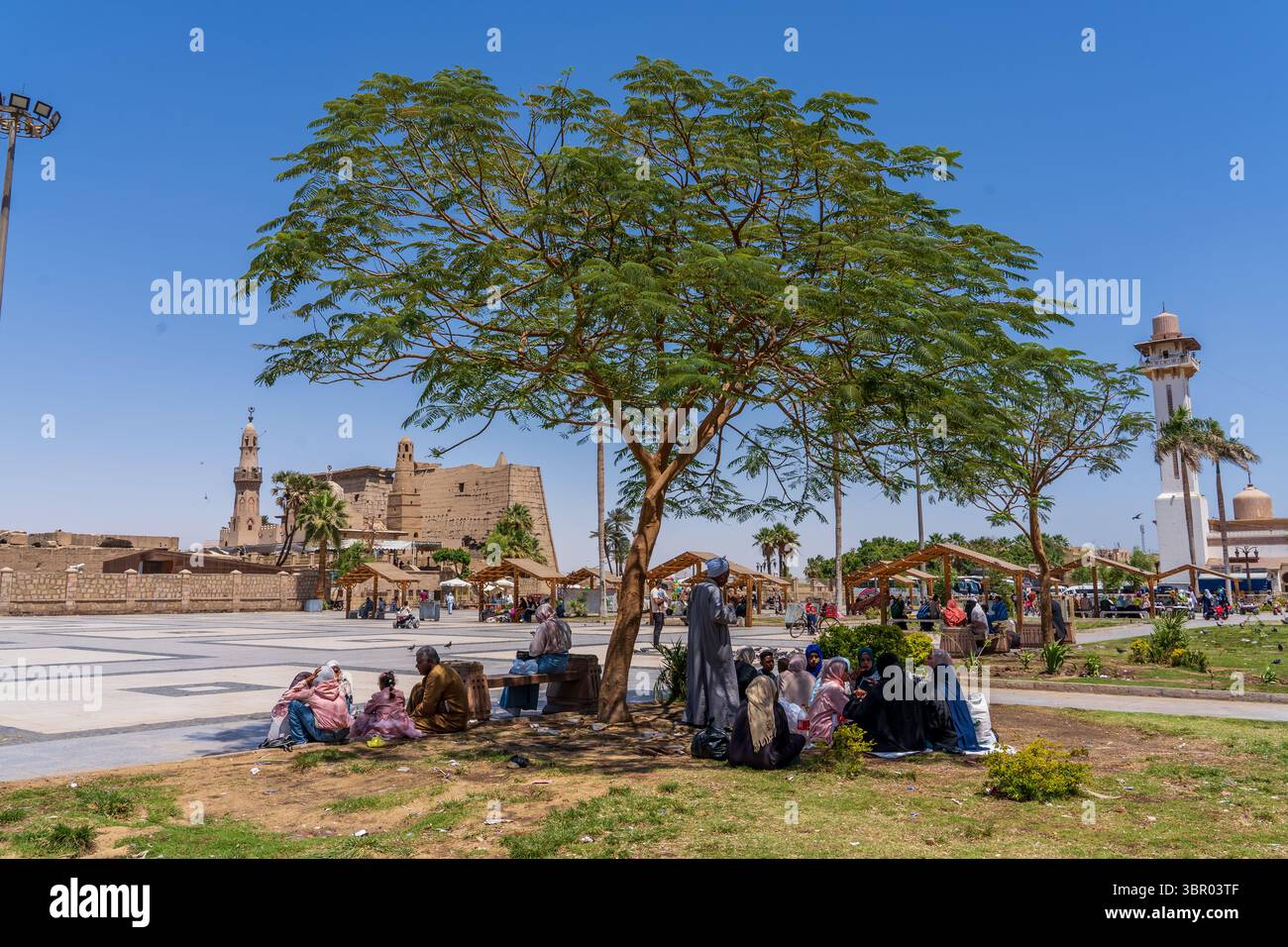 La gente riposa all'ombra vicino al tempio di Luxor, in Egitto Foto Stock
