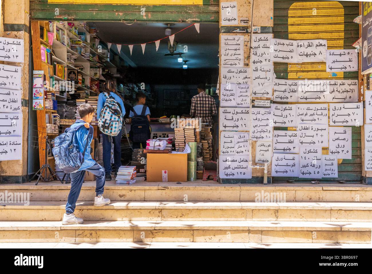 Gli studenti entrano in un negozio di cancelleria, Luor, Egitto Foto Stock