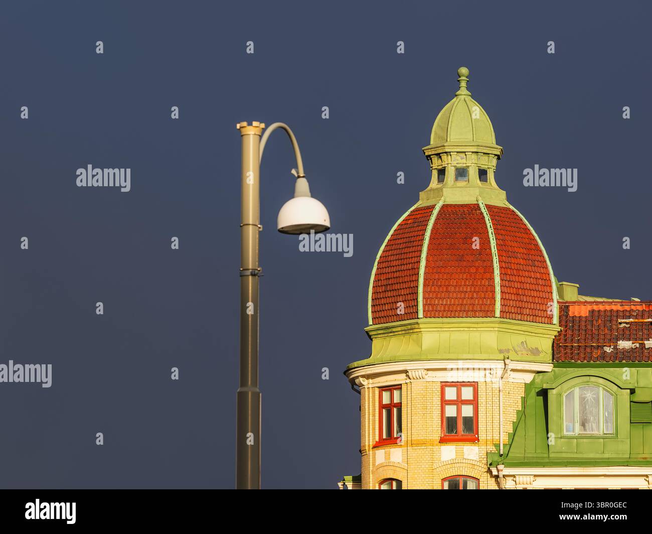 Un lampione si erge di fronte a un edificio storico di Gothenburg, mostrando intricati dettagli architettonici e un cielo scuro e lunare. T Foto Stock