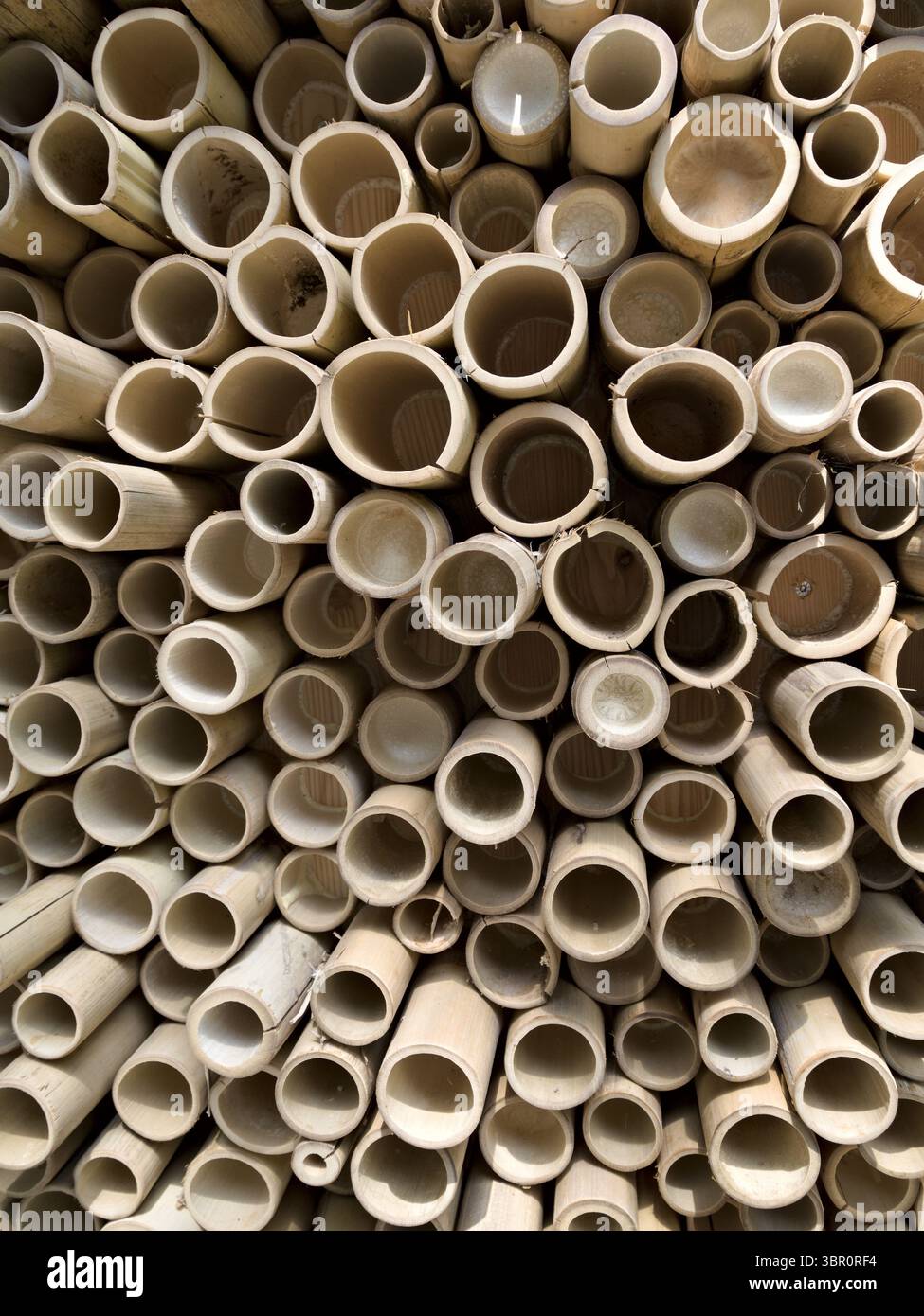 Parete simmetrica in bambù realizzata con bastoncini da taglio, con motivi circolari in legno. Foto Stock