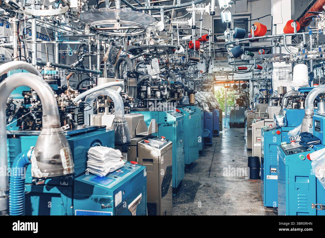Vista industriale delle moderne macchine per maglieria in calze al lavoro nella fabbrica tessile. Produzione industriale di calze Foto Stock