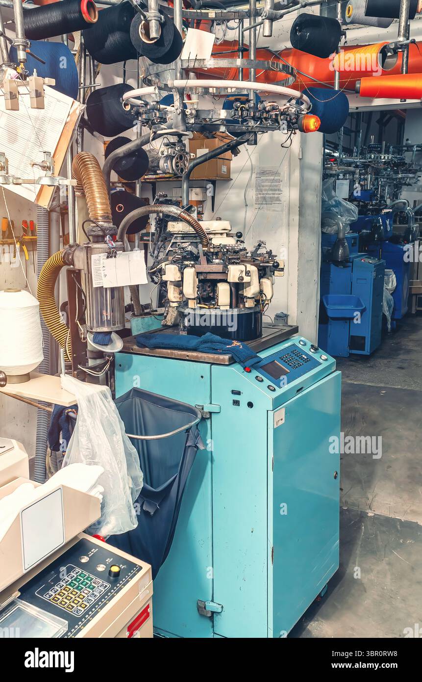 Macchina per maglieria industriale ad alta tecnologia con filettature guida. Produzione industriale di calze, background Foto Stock
