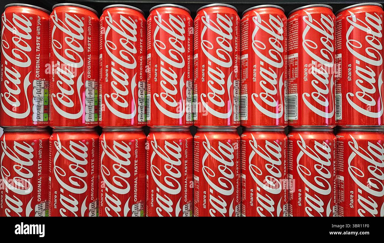 Lattine Coca-Cola impilate in esposizione nel negozio.riga.Lettonia.10.07.2025 - Immagine stock catturata con smartphone