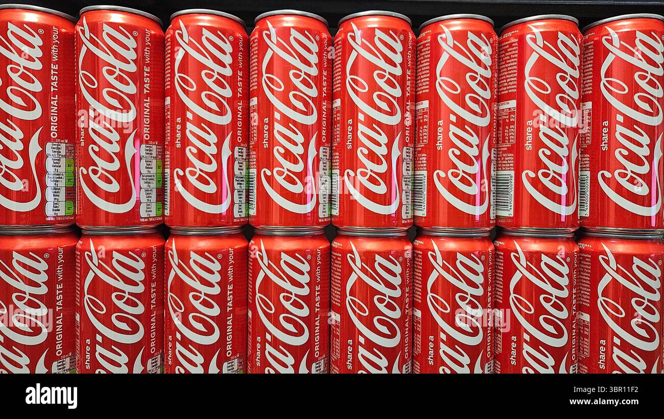 Lattine Coca-Cola impilate in esposizione nel negozio.riga.Lettonia.10.07.2025 - Immagine stock catturata con smartphone