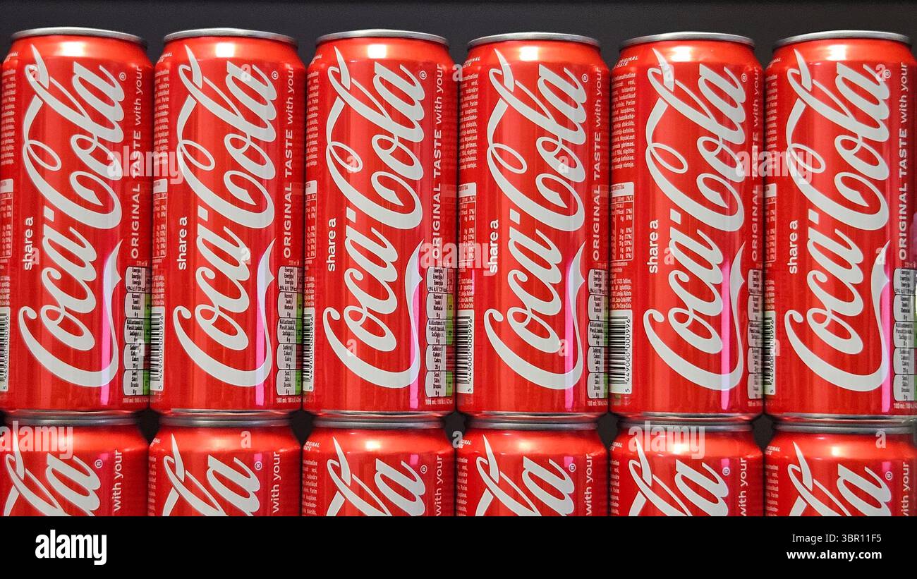 Lattine Coca-Cola impilate in esposizione nel negozio.riga.Lettonia.10.07.2025 - Immagine stock catturata con smartphone