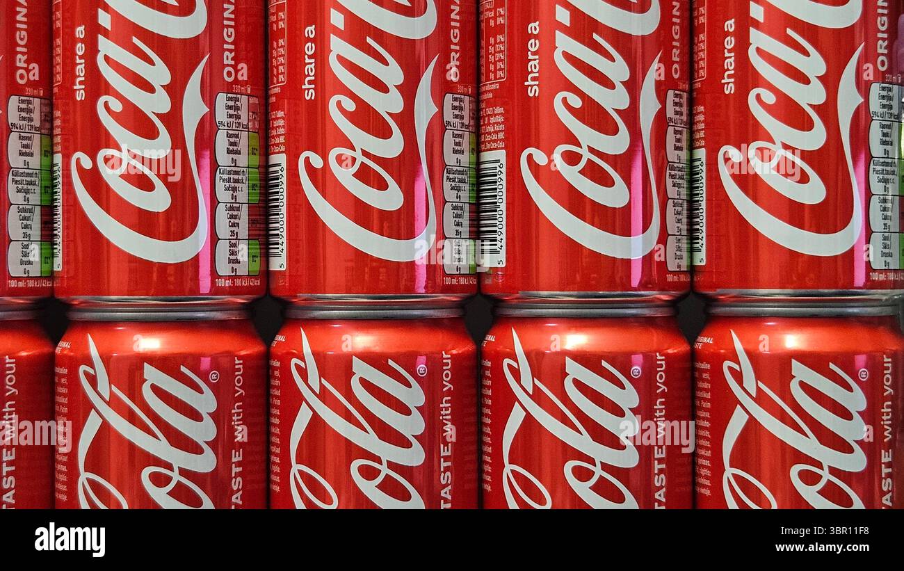 Lattine Coca-Cola impilate in esposizione nel negozio.riga.Lettonia.10.07.2025 - Immagine stock catturata con smartphone