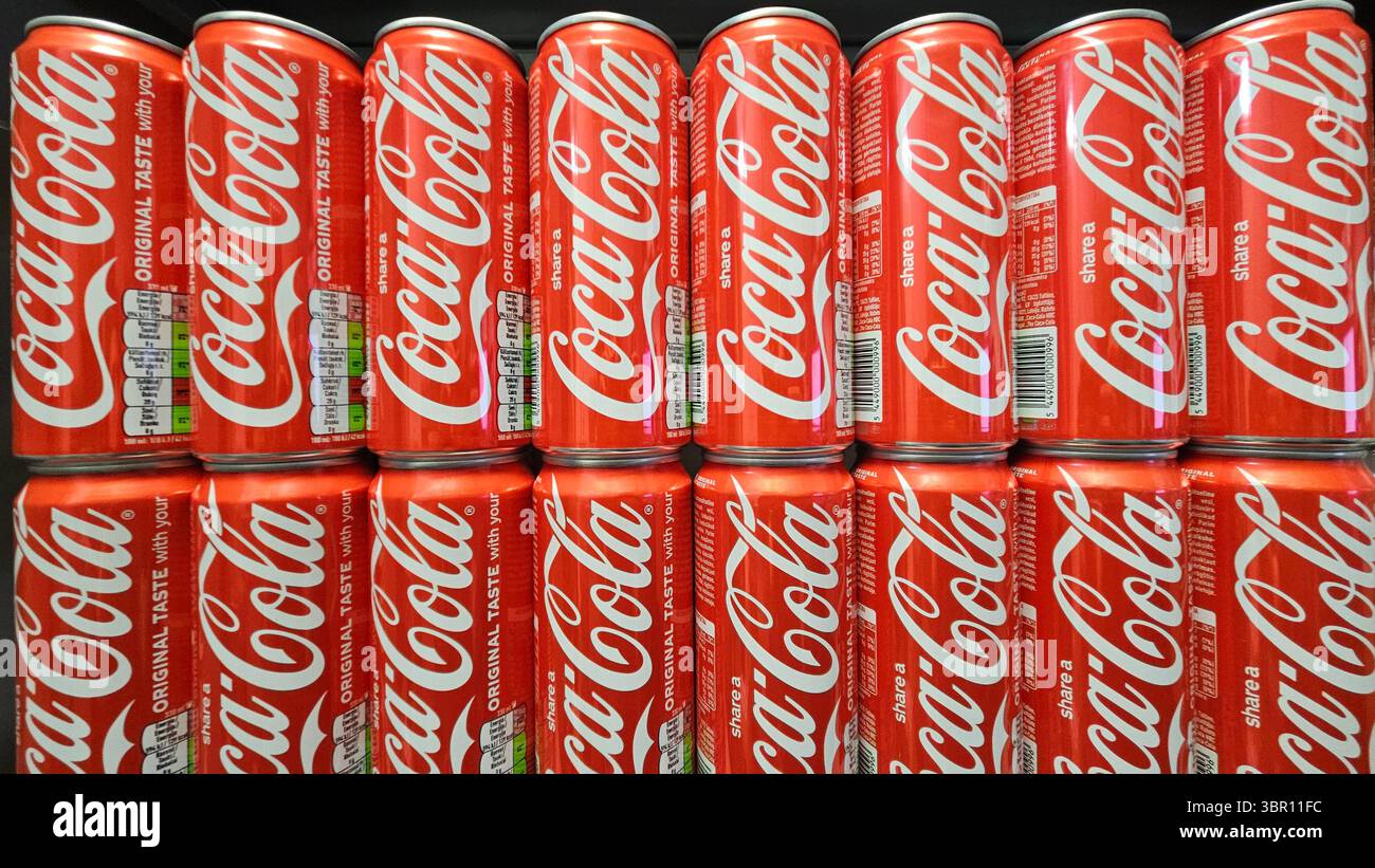 Lattine Coca-Cola impilate in esposizione nel negozio.riga.Lettonia.10.07.2025 - Immagine stock catturata con smartphone