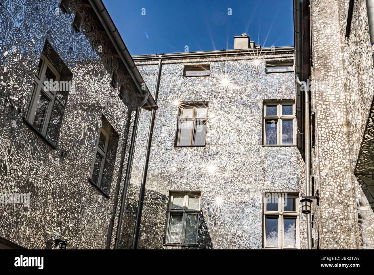 Łódź, Polonia. Un cortile coperto da piastrelle a mosaico a specchio che riflettono la luce del sole e creano effetti artistici di luce sulle pareti. Foto Stock