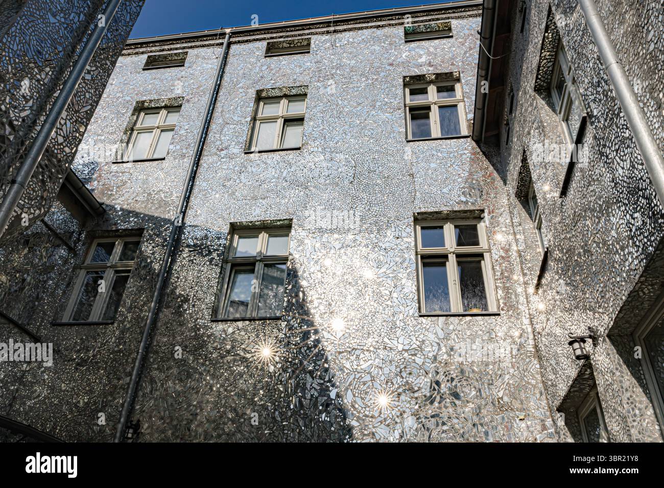 Łódź, Polonia. Un cortile coperto da piastrelle a mosaico a specchio che riflettono la luce del sole e creano effetti artistici di luce sulle pareti. Foto Stock