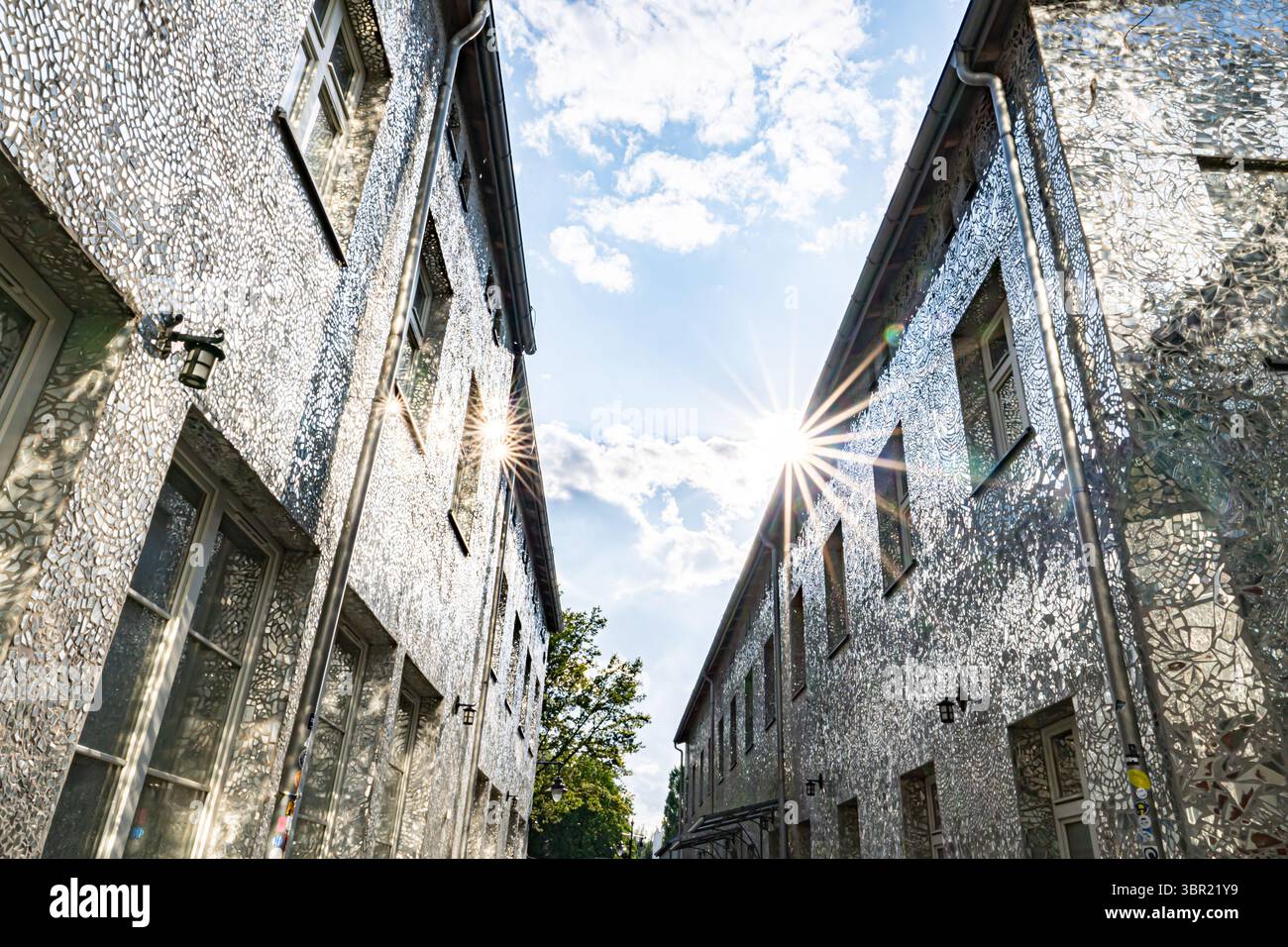 Łódź, Polonia. Un cortile coperto da piastrelle a mosaico a specchio che riflettono la luce del sole e creano effetti artistici di luce sulle pareti. Foto Stock