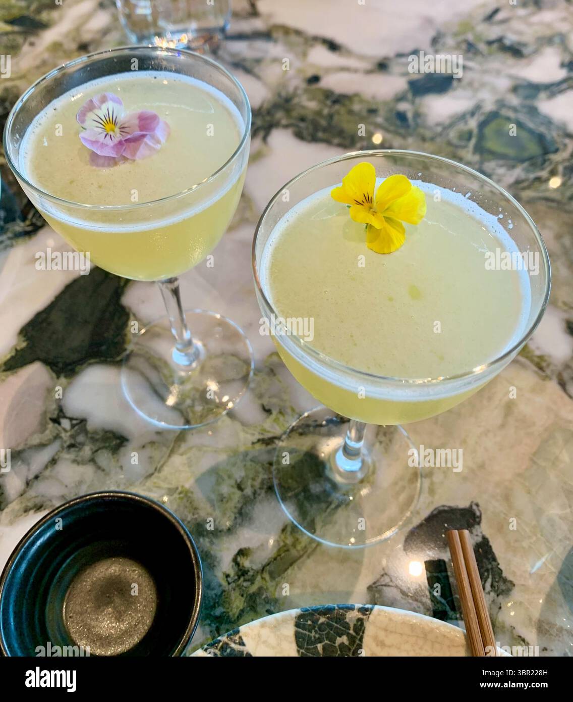 Vivace mocktail Martini al frutto della passione e ai fiori di sambuco - una bevanda rinfrescante senza alcol servita elegantemente e ricca di aroma tropicale. Foto Stock