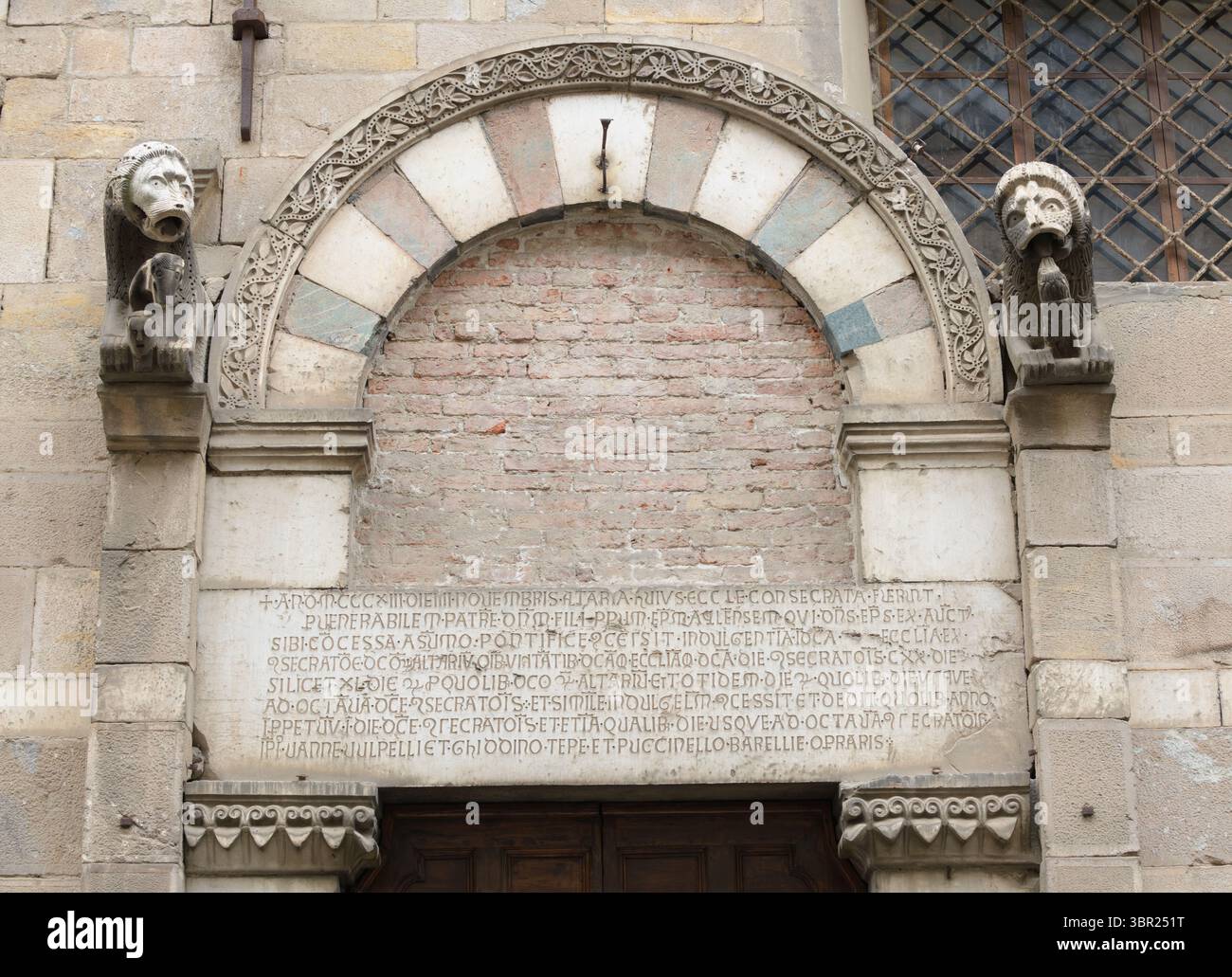 Particolare del portale in marmo romanico con leoni scolpiti e iscrizione latina, chiesa di Santa Maria Corteorlandini, Lucca, Italia. Foto Stock