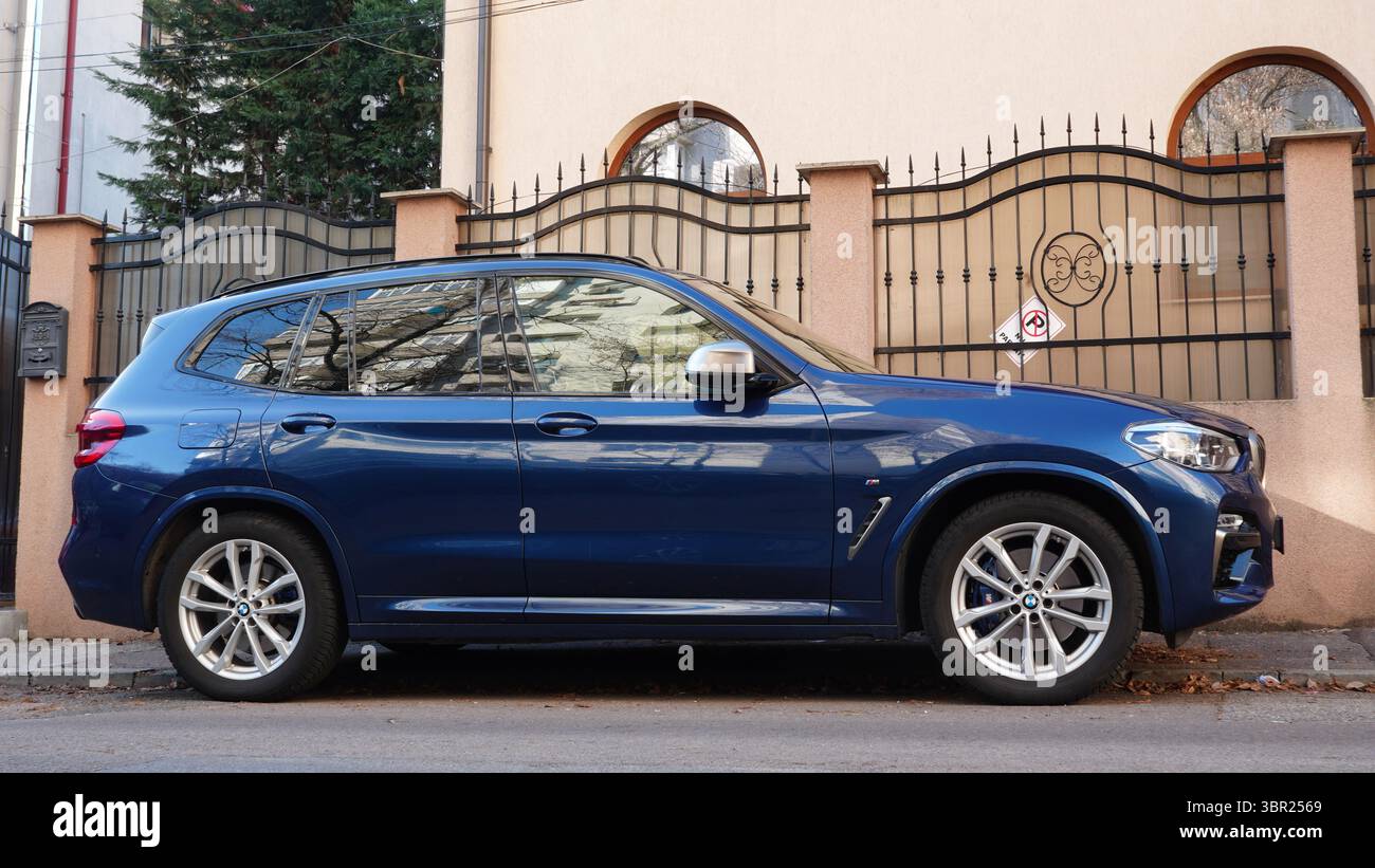 Bucarest, Romania – 9 gennaio 2025: Vista laterale ravvicinata della BMW X3 M40i auto blu parcheggiata di fronte alla casa Foto Stock