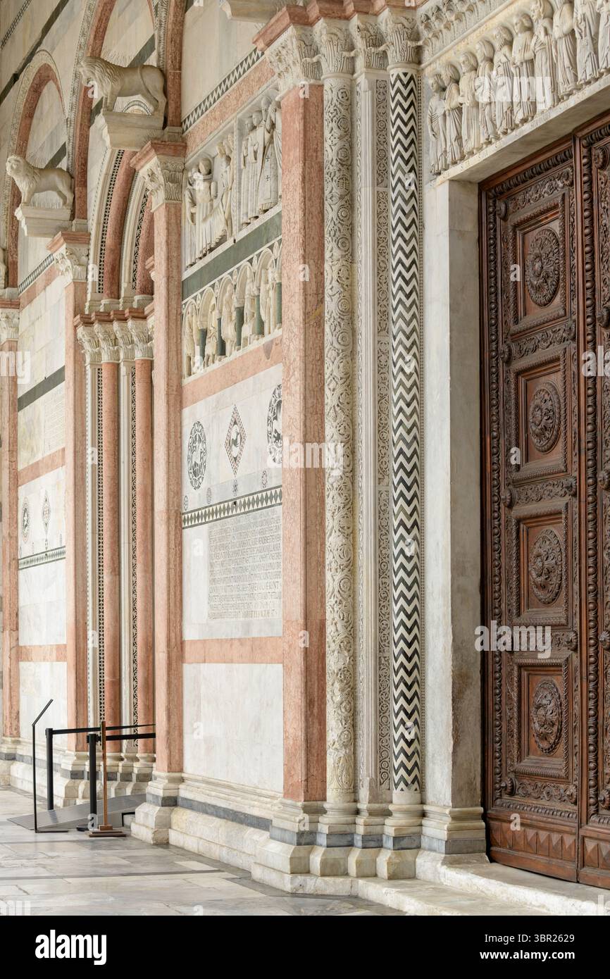 Portale romanico con colonne in marmo e arco scolpito nella Cattedrale di San Martino, Lucca, Italia. Foto Stock