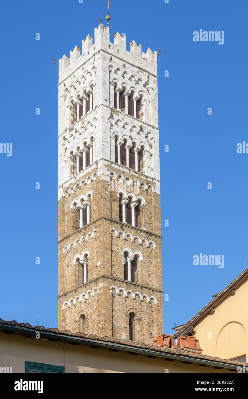 Campanile romanico della Cattedrale di San Martino a Lucca, Italia, con livelli alternati di pietra bianca e marrone, triplice lance e merlature. Foto Stock