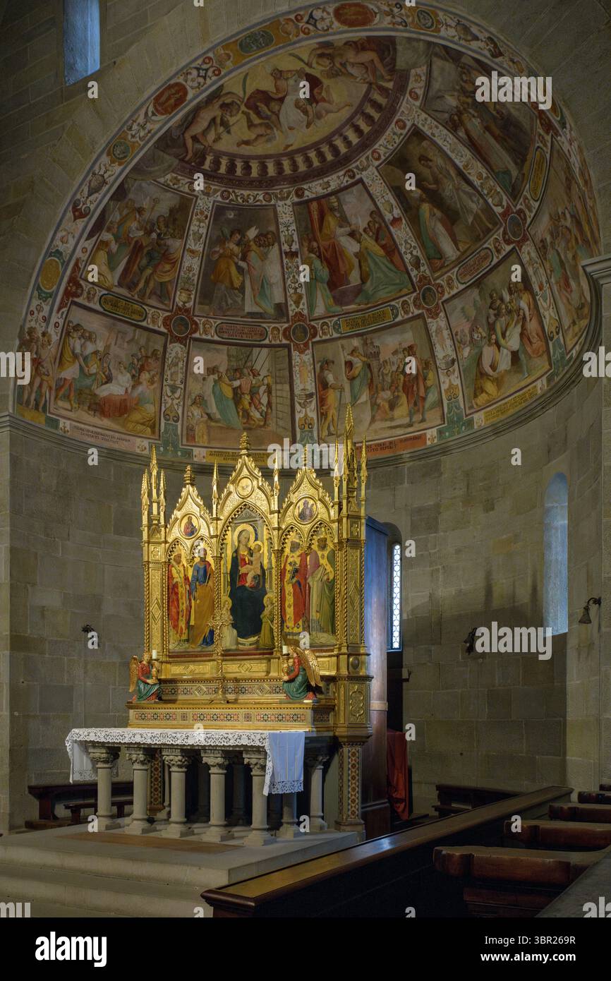 Abside romanica all'interno della Cattedrale di San Romolo a Fiesole, in Italia, caratterizzata da archi semicircolari, altare e austera architettura medievale. Foto Stock