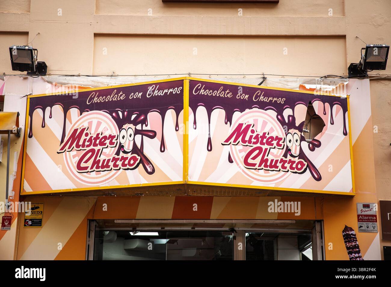 VALENCIA, SPAGNA - 15 APRILE 2025: Il cartello di Mister Churro Chocolate con Churros, decorato con una grafica di cioccolato che gocciola, segna un chiosco di churro su una vale Foto Stock