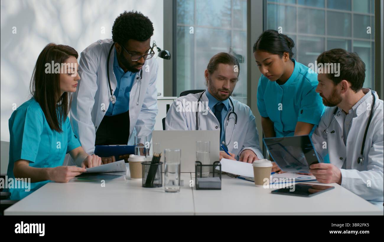 Gruppo di lavoro di squadra team multietnico diversi medici collaborazione persone mediche brainstorming utilizzando laptop discutere medicina malattia parlare paziente Foto Stock