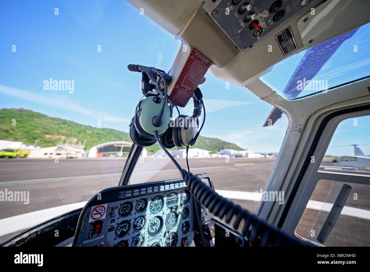 Interni in elicottero, cuffie e cruscotto, a terra all'aeroporto in attesa del decollo, trasporto aereo Foto Stock