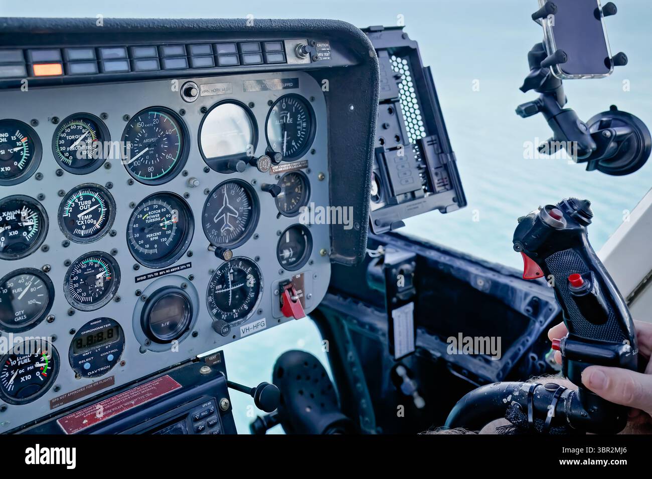 Cruscotto interno dell'elicottero, pilota con comandi, volo in basso sull'acqua Foto Stock