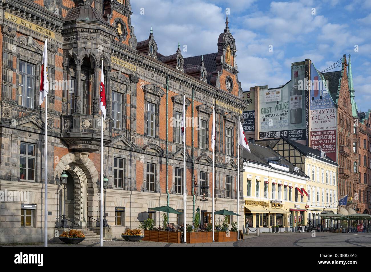 Dettaglio della facciata del municipio in mattoni in stile rinascimentale olandese e nostalgici manifesti pubblicitari sulla facciata laterale di un secondo edificio in mattoni Foto Stock