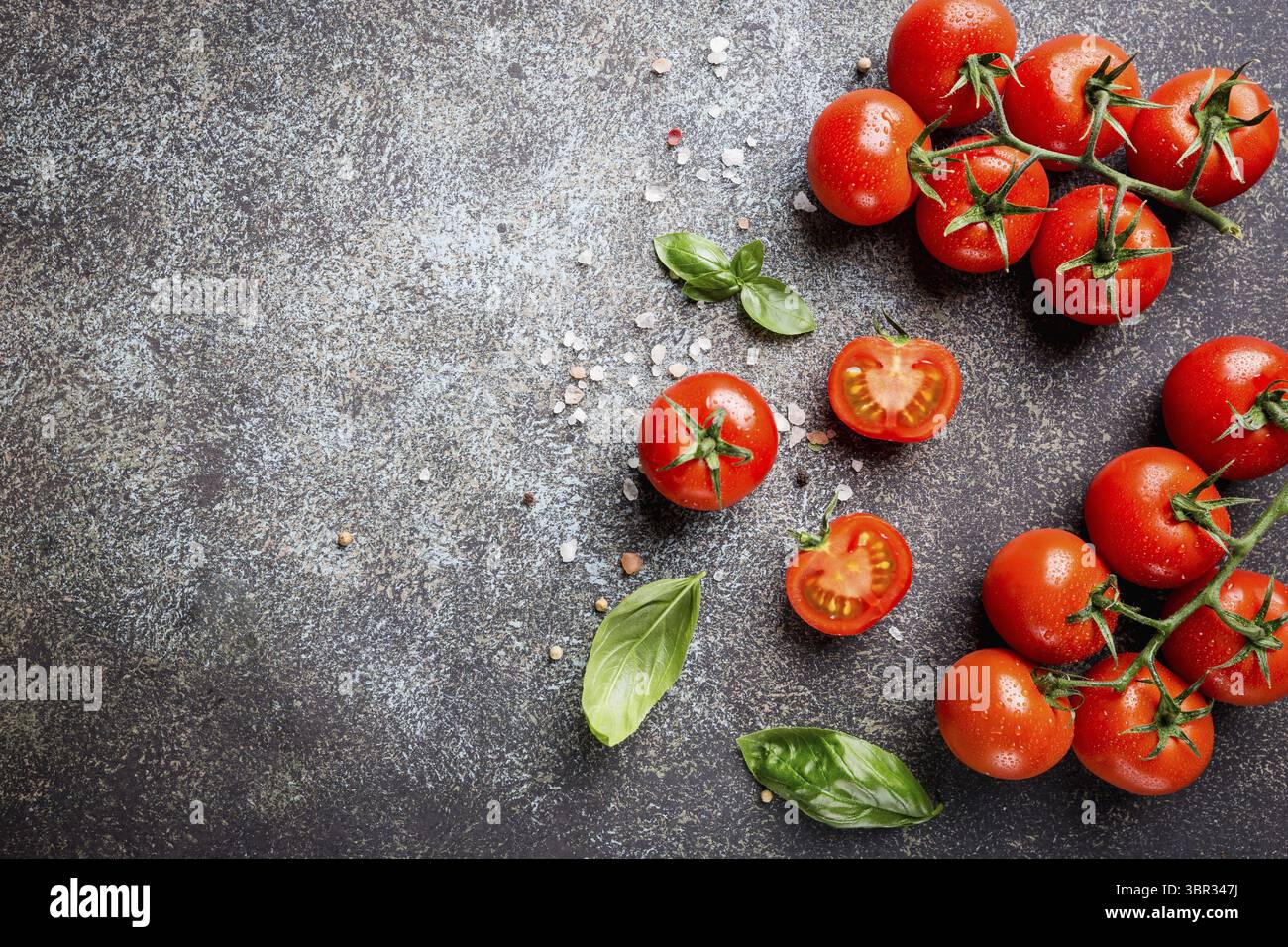 Mosti di uve fresche pomodori con basilico e sale grosso, vista dall'alto con spazio di copia Foto Stock