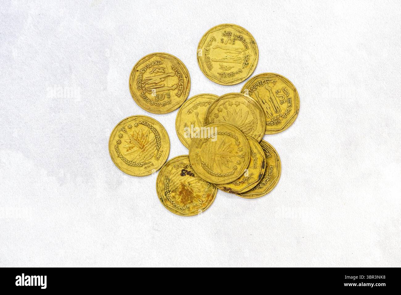 Collezione di vecchie monete di ottone da 1 BDT Bangladesh Taka, datate 1996 e 1999, sparse con entrambi i lati visibili. Foto Stock