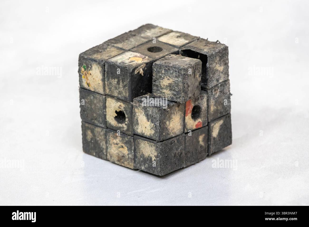 Il vecchio giocattolo Rubik's Cube in primo piano mostra pezzi rotti, plastica rigata e nessun colore originale rimanente. Foto Stock