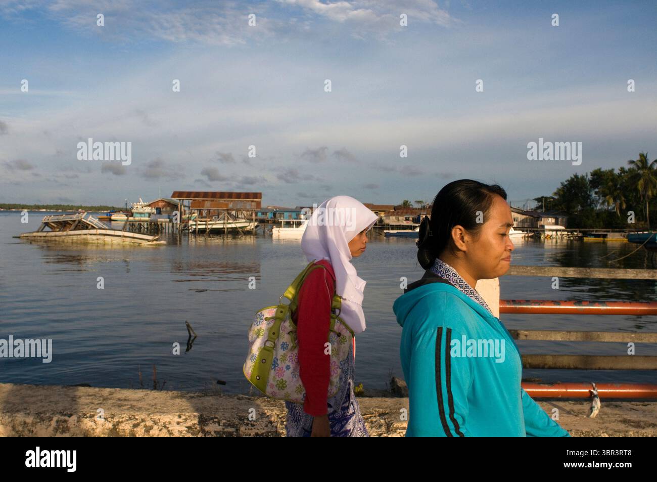 6 aprile 2010, Semporna, Borneo, Malesia: Porto di Senporna nel parco marino Tun Sakaran, Sabah, Borneo, Malesia orientale. Due donne locali camminano lungo il molo di Semporna. SLA Sipadan: L'isola di Sipadan è l'unica isola oceanica dell'arcipelago malese. Ha un paesaggio unico in quanto non condivide la solita strada dalle spiagge dell'arcipelago; ma è, come suggerisce la figura, un fungo che sporge dall'acqua. L'isola può ospitare solo 160 persone; ma dall'inizio di quest'anno è assolutamente vietato soggiornare in essa. È consentito solo al momento; immersioni. Tuttavia, in 15 o 20 minuti, è possibile Foto Stock