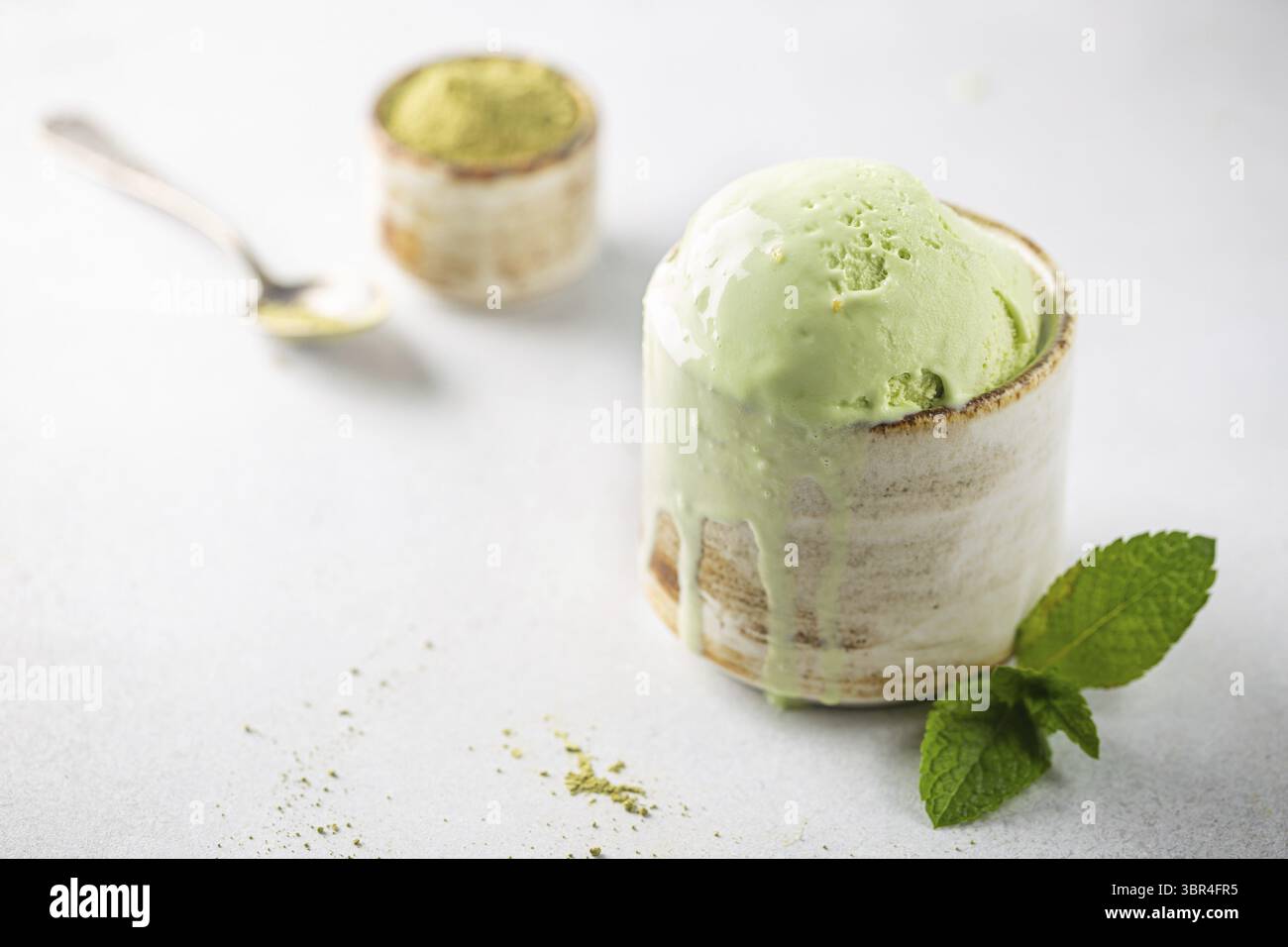 Tazza di gelato al tè verde su fondo bianco Foto Stock