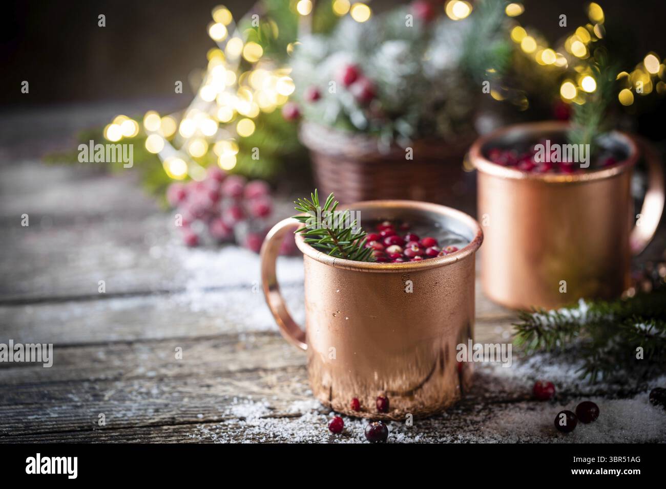 VIN brulé con mirtillo rosso in tazza di rame con decorazioni natalizie su tavolo di legno Foto Stock