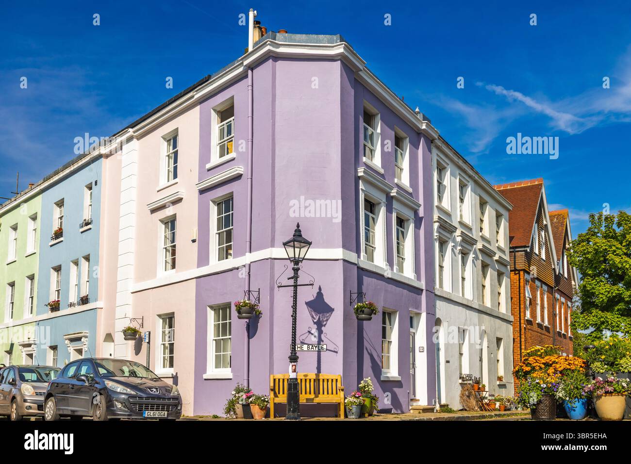 Vivaci case a schiera color pastello in una strada soleggiata all'angolo. Folkestone, Regno Unito, 11 maggio 2024 Foto Stock
