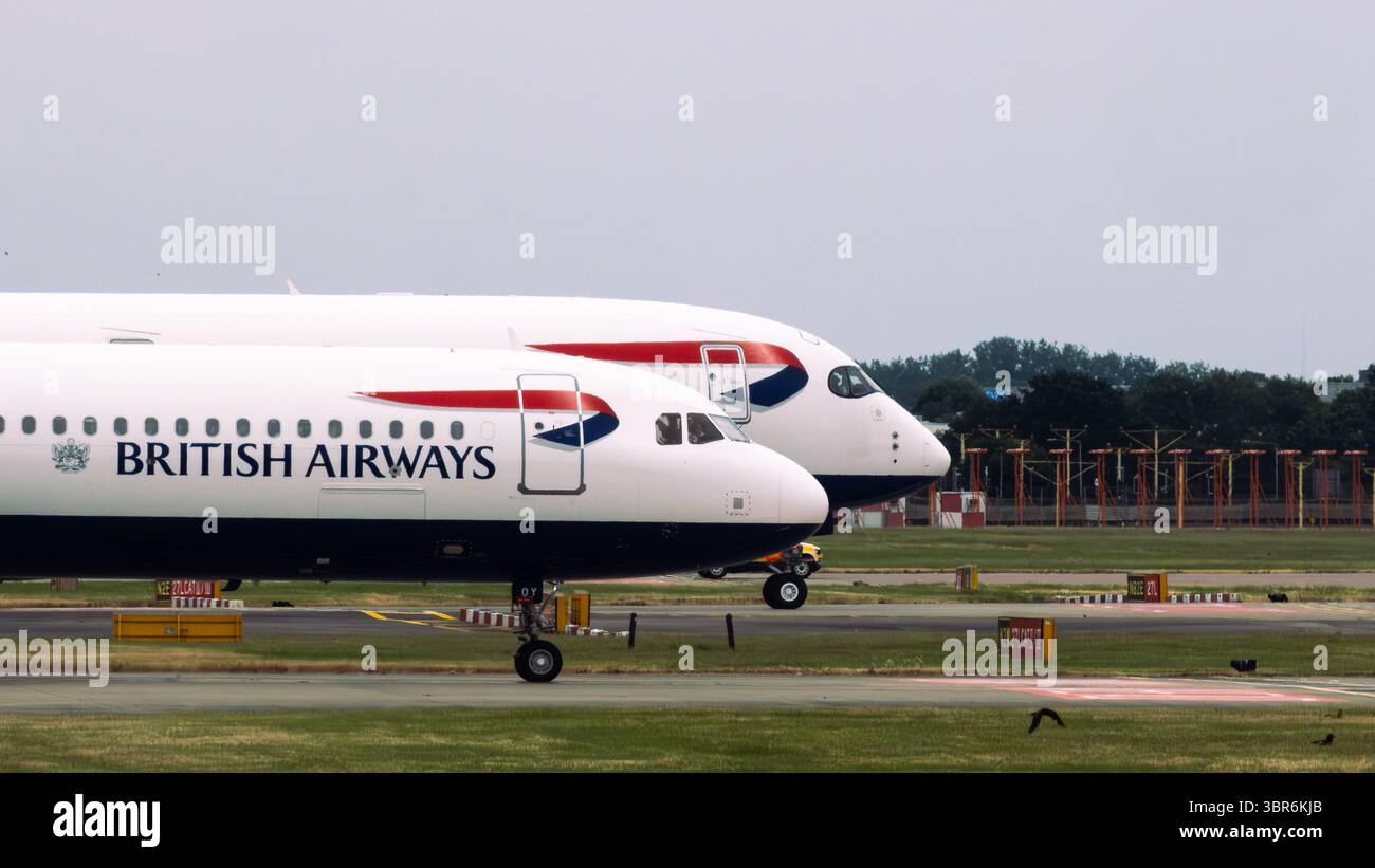 Due aerei della British Airways airbus sulla pista, allineati uno dietro l'altro con il marchio visibile. Foto Stock