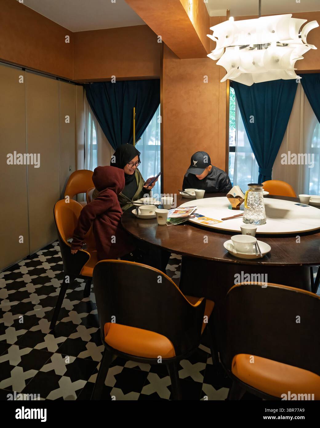 La famiglia pranza allo Uncle Kadeer, ristorante musulmano cinese Foto Stock