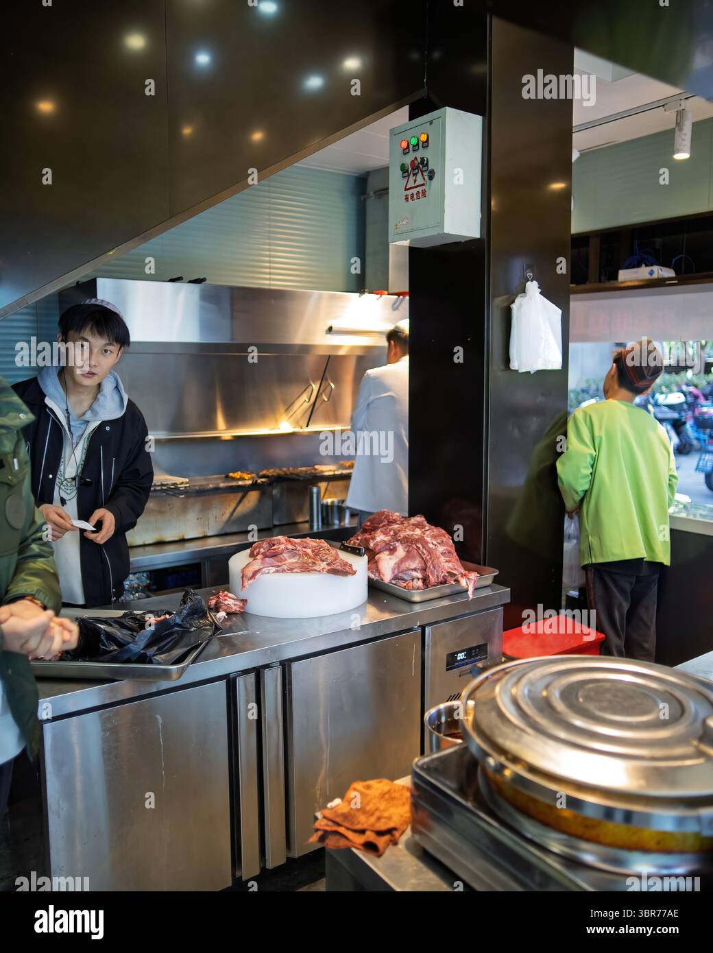 Il personale del ristorante cinese musulmano Zinjiang era occupato in cucina. Foto Stock