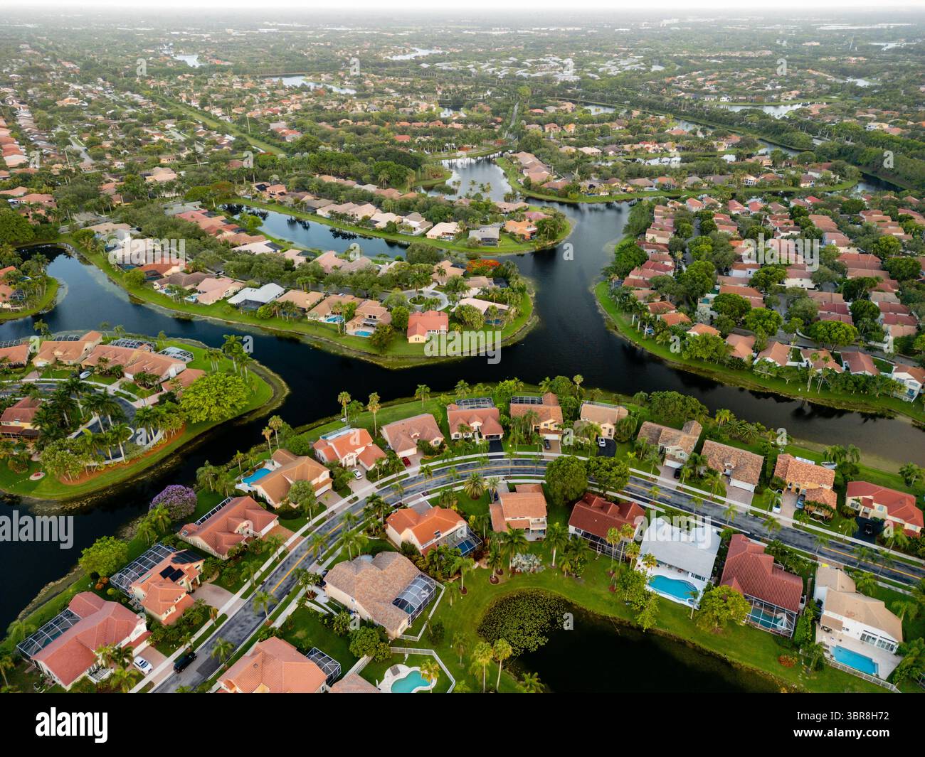 Vista aerea dei tortuosi corsi d'acqua che si intrecciano tra case e piscine, creando un vivace arazzo di blu e verde, Weston, Florida, Stati Uniti. Foto Stock