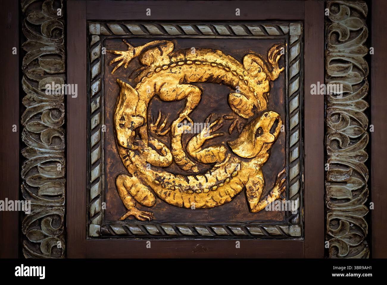 WASHINGTON DC - le porte d'ingresso ornate in legno del Reptile Discovery Center presentano sculture in rilievo d'oro di stegosauro e altri rettili, con maniglie delle porte modellate come serpenti intrecciati. Le porte decorative, risalenti al 1931, facevano parte del progetto completo dell'architetto Albert L. Harris per l'edificio, che includeva il famoso mosaico di stegosaurus creato attraverso la collaborazione con il paleoartista Charles R. Knight e il pioniere del cemento John Joseph Earley. Le porte completano lo stile architettonico bizantino-romanico dell'edificio e riflettono l'approccio dell'era Progressista alla fusione scientifica Foto Stock